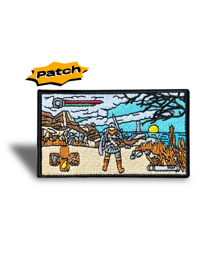 An embroidered rectangular patch featuring a fantasy desert scene with a warrior, desert dunes, a sword, and a sword hilt, shown on a white background with a yellow 'patch' label above.