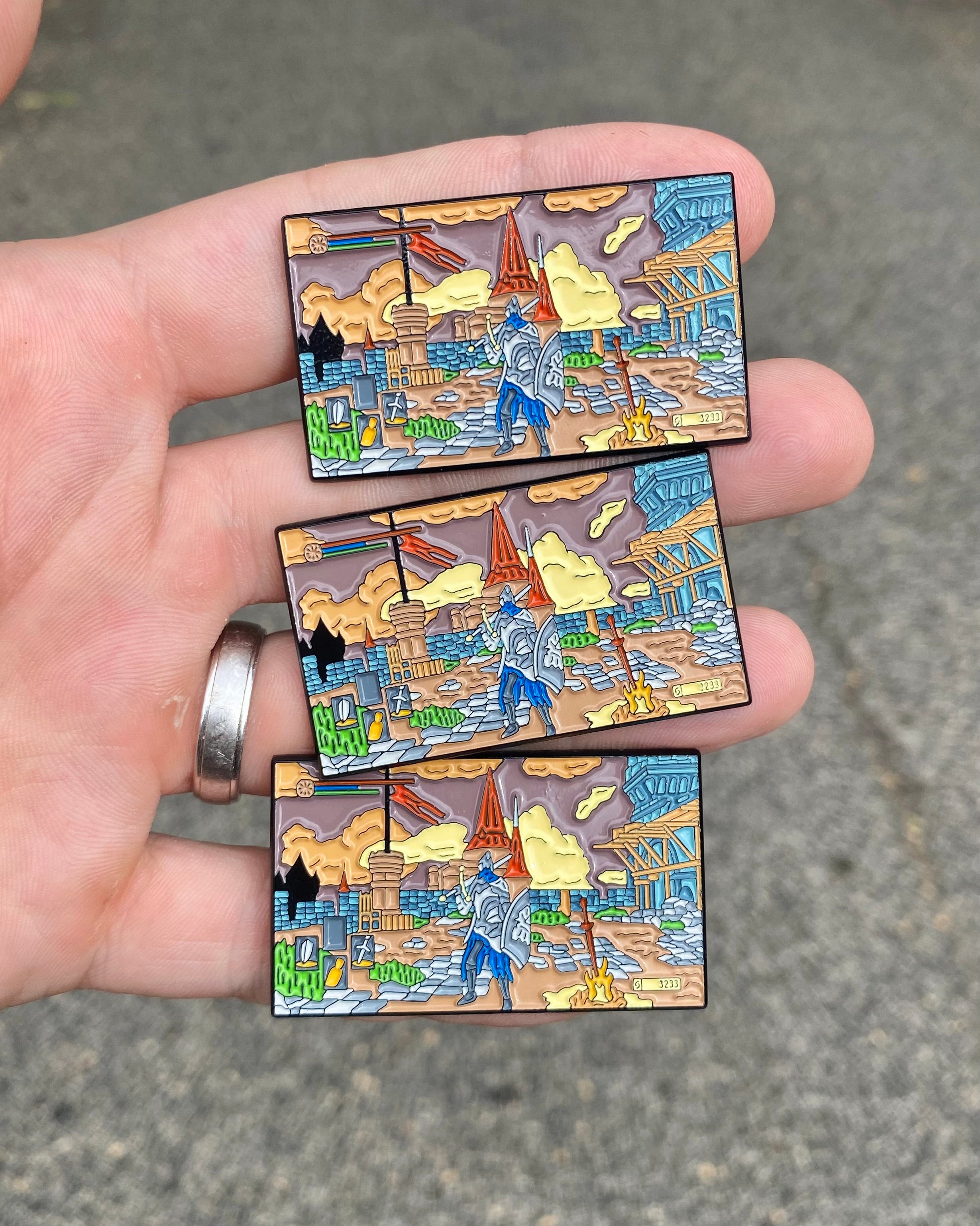 Three Dark Souls Praise the Sun enamel pins held in hand