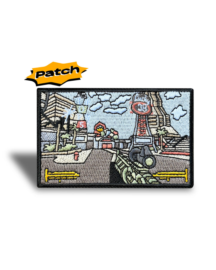 An embroidered rectangular patch featuring a vintage-style street scene with a motorcycle, buildings, clouds, and a sign reading '48'. A yellow 'Patch' label is shown above the product on a white background.