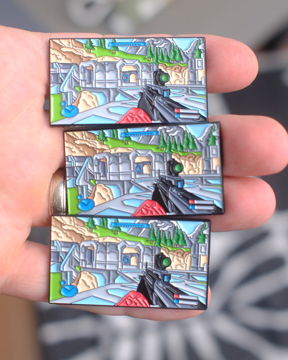 Three Halo Reach Forge World enamel pins held in hand