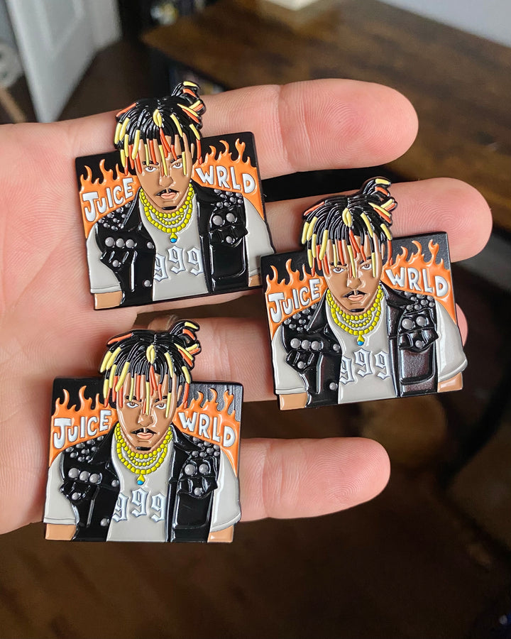 Three Juice WRLD 999 enamel pins held in hand
