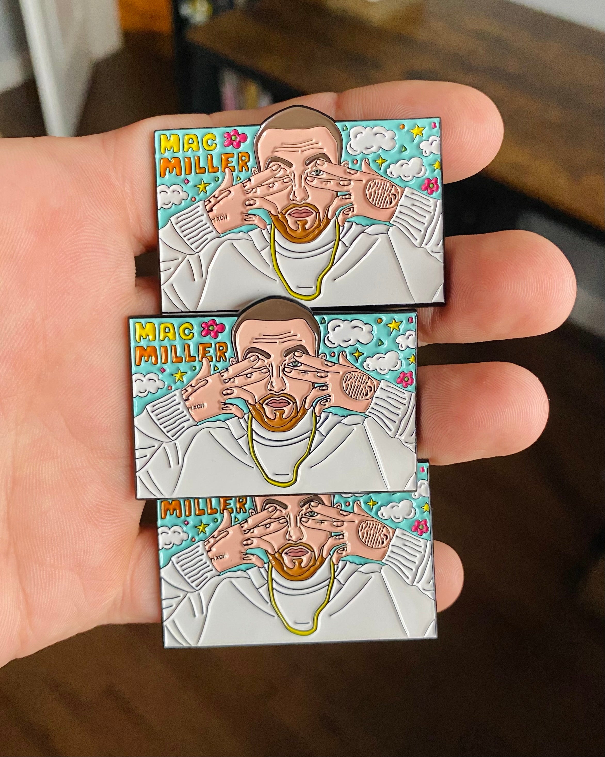 Three Mac Miller Dont Trip enamel pins held in hand