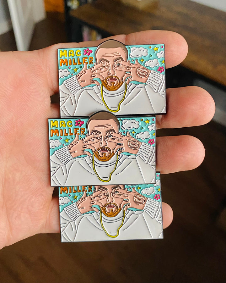 Three Mac Miller Dont Trip enamel pins held in hand