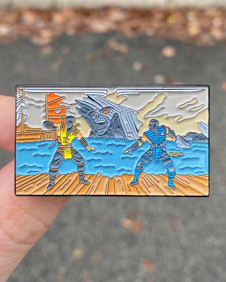 Mortal Kombat Fatality enamel pin held in hand