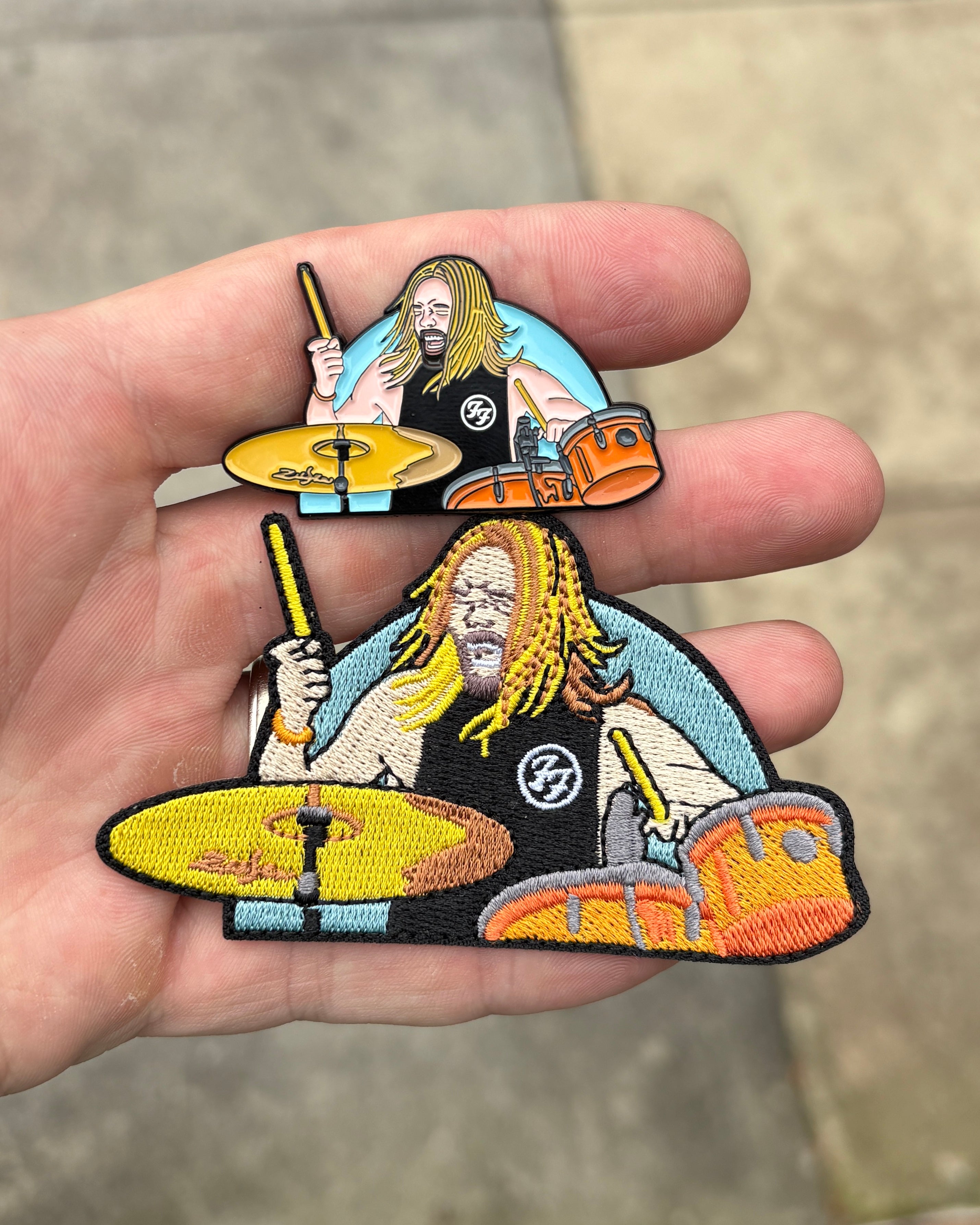 Taylor Hawkins Foo Fighters drummer embroidered patches in two sizes held in hand