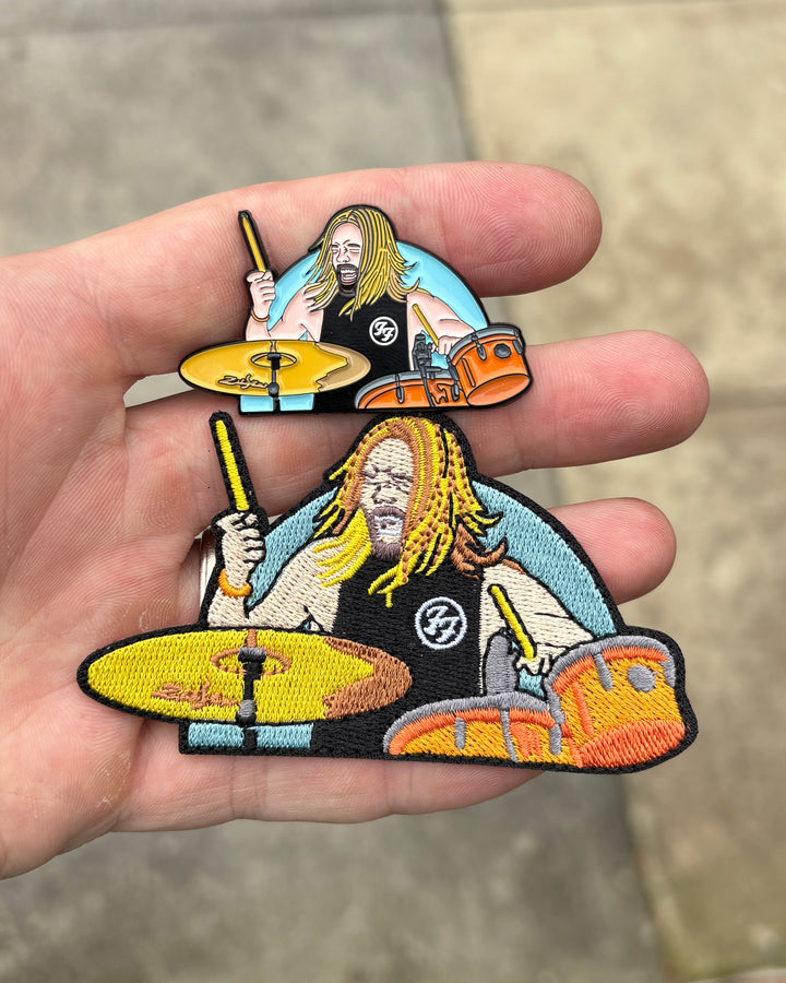 Taylor Hawkins Foo Fighters drummer embroidered patches in two sizes held in hand
