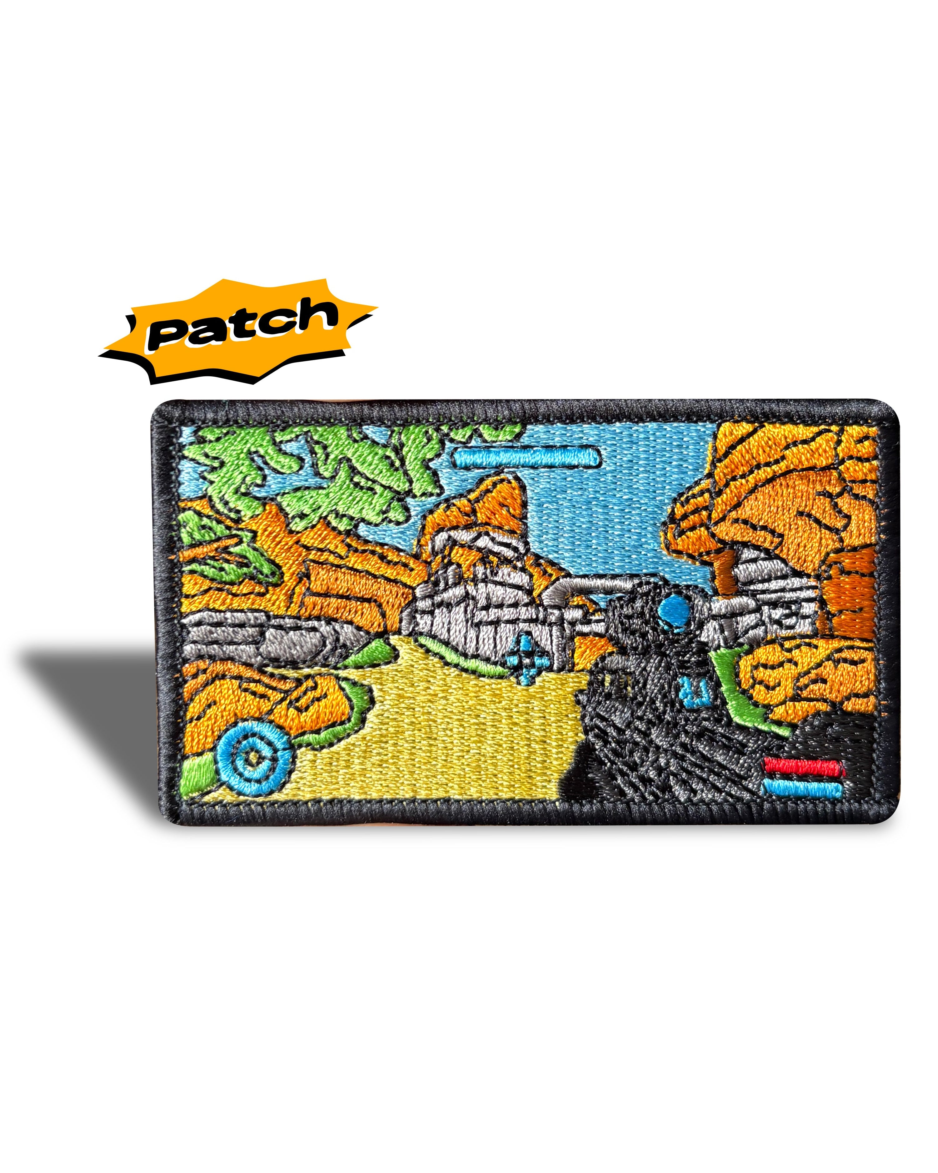 An embroidered rectangular tactical patch featuring a colorful fantasy landscape with orange rock formations, a blue sky, and a black vehicle, shown on a white background with a yellow 'patch' logo overlay.